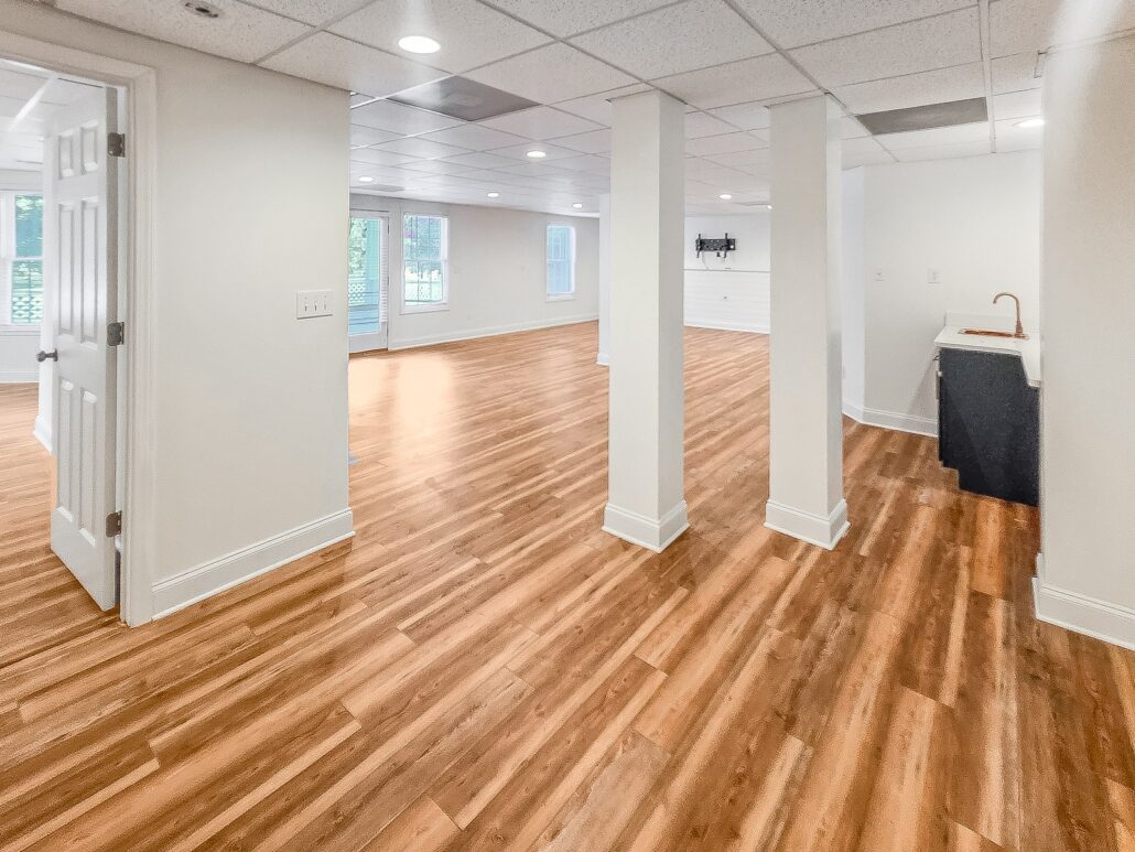Finished walkout basement at 1030 Billy Mantle Lane with wood-look plank floors and a wet bar
