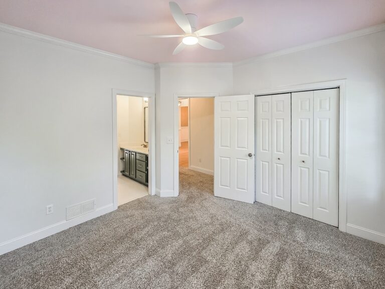 Main-level bedroom with a ceiling fan, double closet and a door to the Jack-and-Jill bath at 1030 Billy Mantle Lane