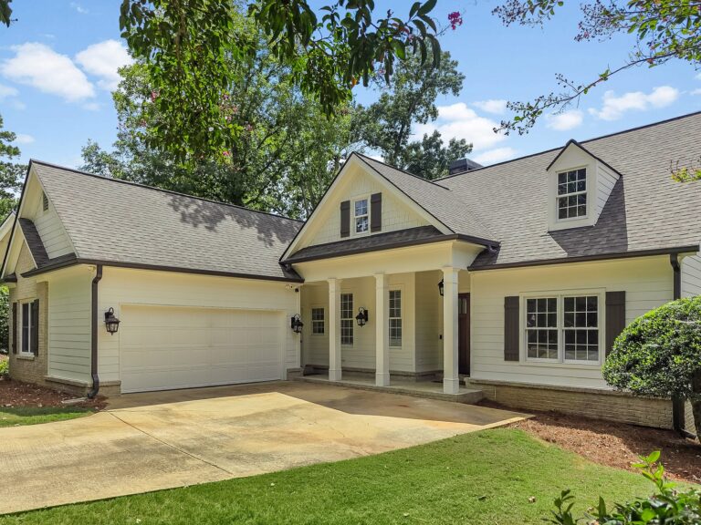 Covered front porch with square columns beside the two-car garage at 1030 Billy Mantle Lane