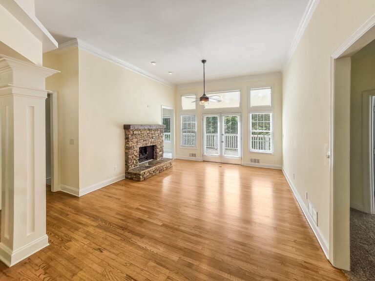 Living room with tall transom windows over French doors to the deck at 1030 Billy Mantle Lane