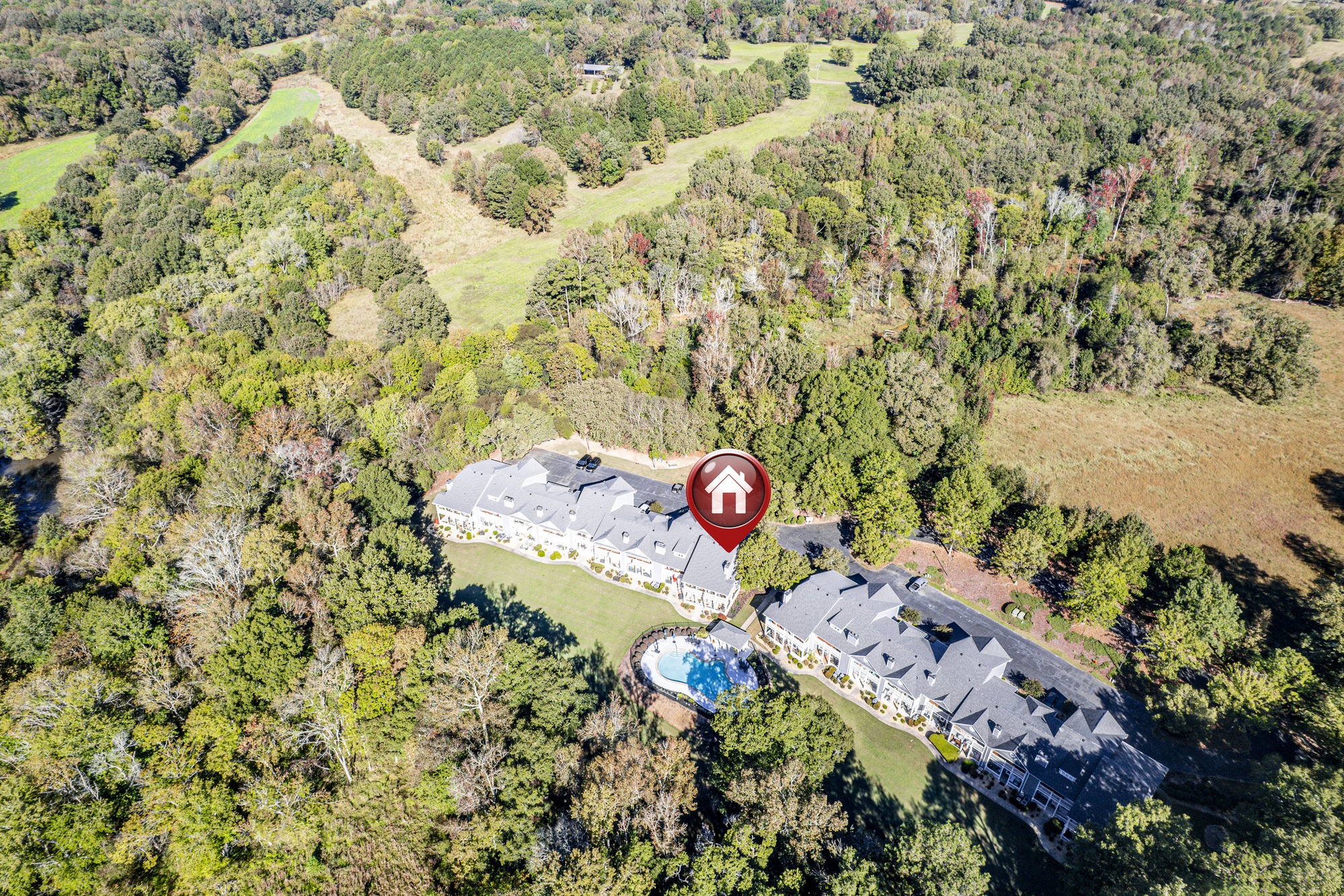 Aerial of the two Carriage Cove buildings and the pool beside a cove of Lake Oconee in Eatonton
