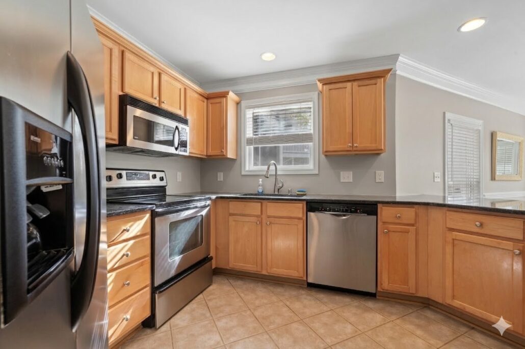 Kitchen with black granite counters, wood cabinets and stainless appliances in an Eatonton condo on Lake Oconee