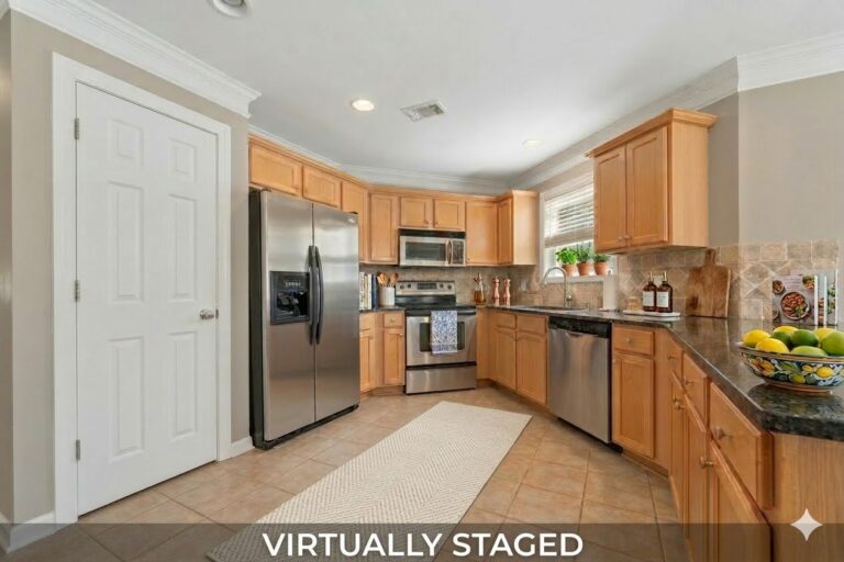 Virtually staged kitchen and stainless refrigerator in the Carriage Cove townhome at 181-A Farriers Lane