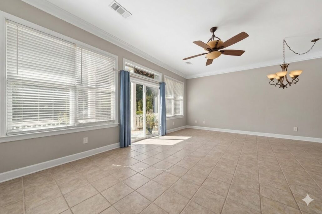Living and dining space with tall windows and tile floors in an end-unit Lake Oconee condo for sale