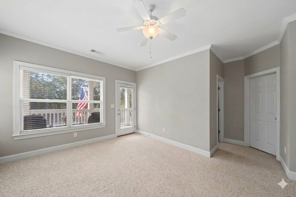 Primary bedroom with a glass door to its covered porch in a Lake Oconee townhome for sale in Carriage Cove