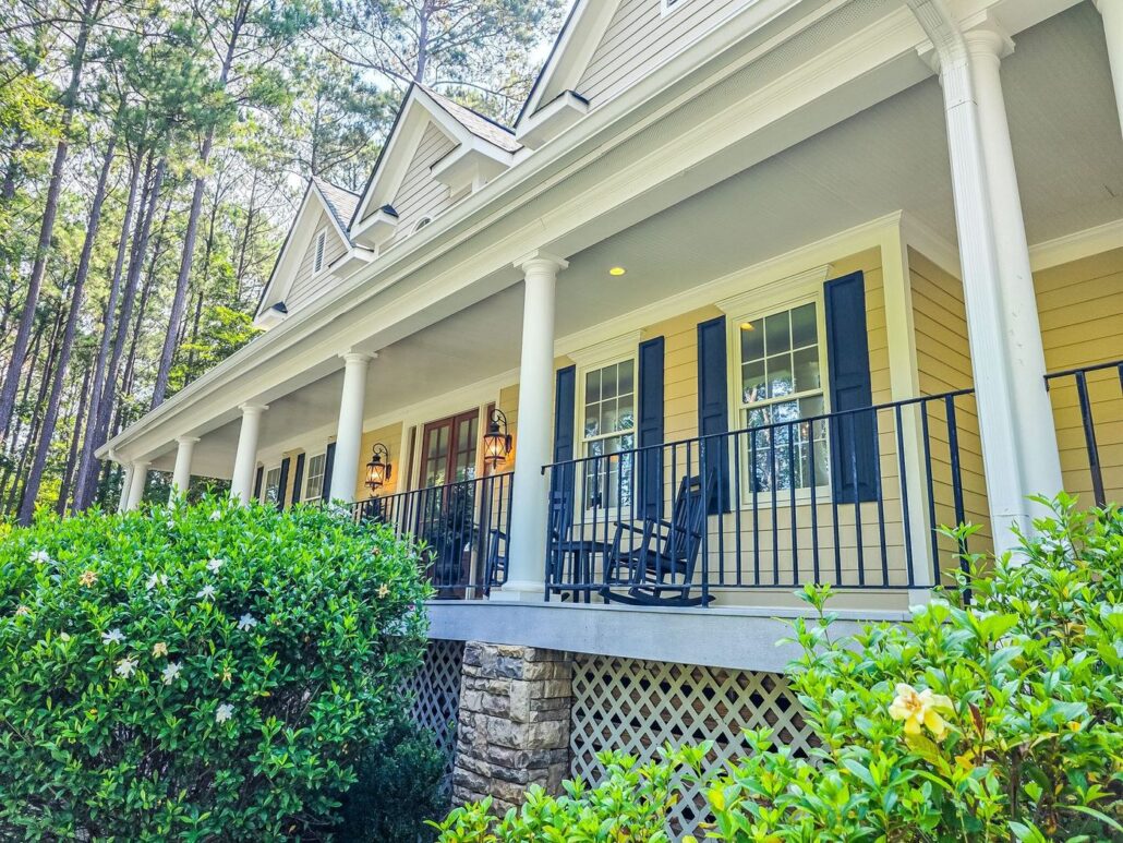 Covered front porch with white columns and rocking chairs at 2750 Club Drive in Harbor Club