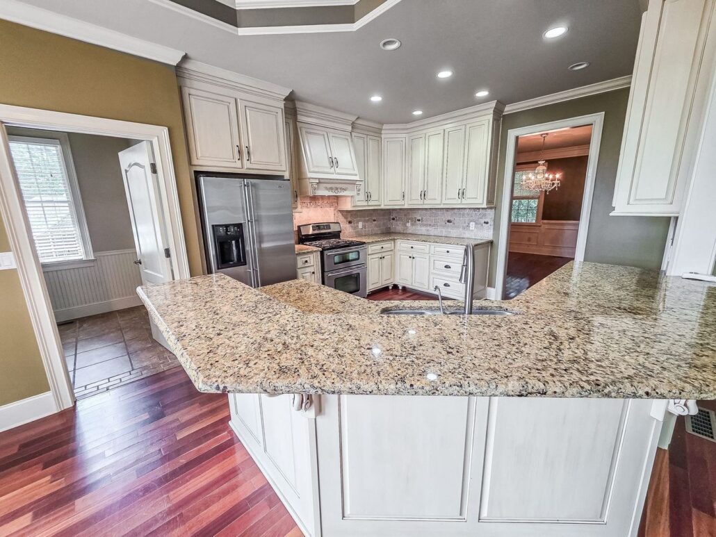 Granite kitchen island with breakfast bar seating at 2750 Club Drive in Harbor Club