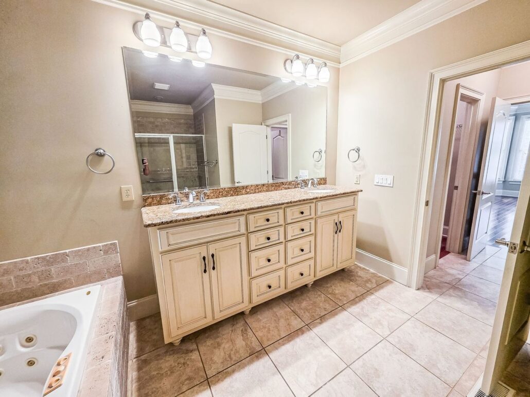 Primary bathroom with a corner jetted tub and double vanity at 2750 Club Drive