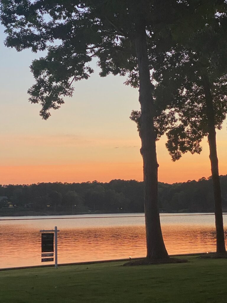 Margie Sorrell's listing sign on a Lake Oconee lakefront at sunset in 2019