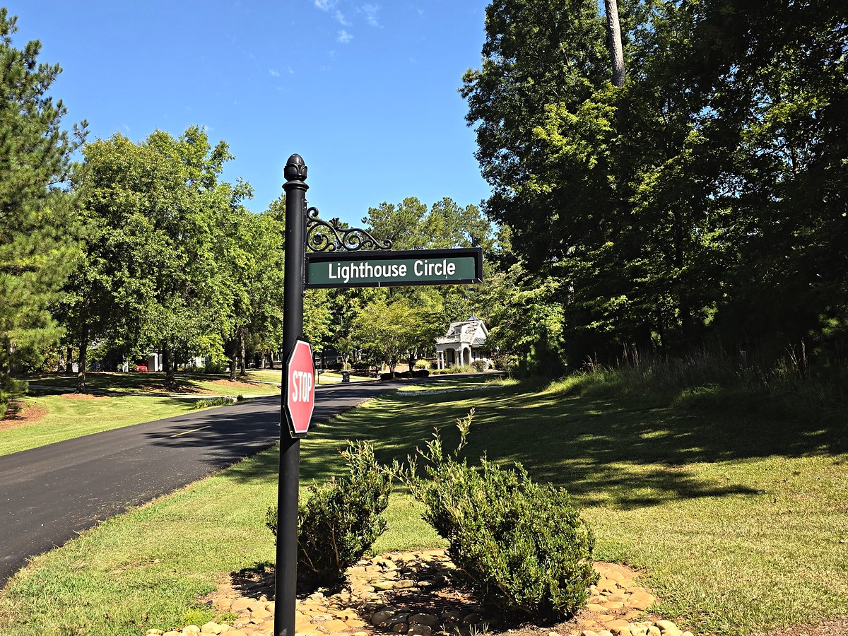 Lighthouse Circle street sign at Lighthouse Point in Harbor Club on Lake Oconee, Georgia, with the old gatehouse beyond