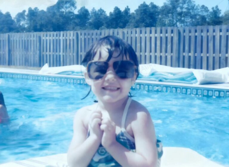 Margie Sorrell as a little girl in oversized sunglasses at the pool