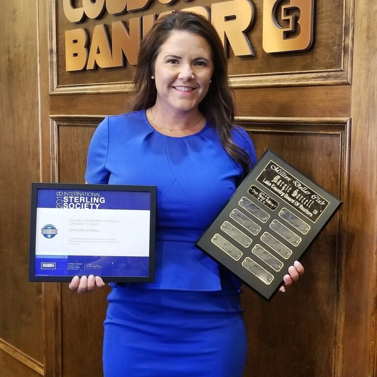 Margie Sorrell holding Coldwell Banker Sterling Society awards in 2018