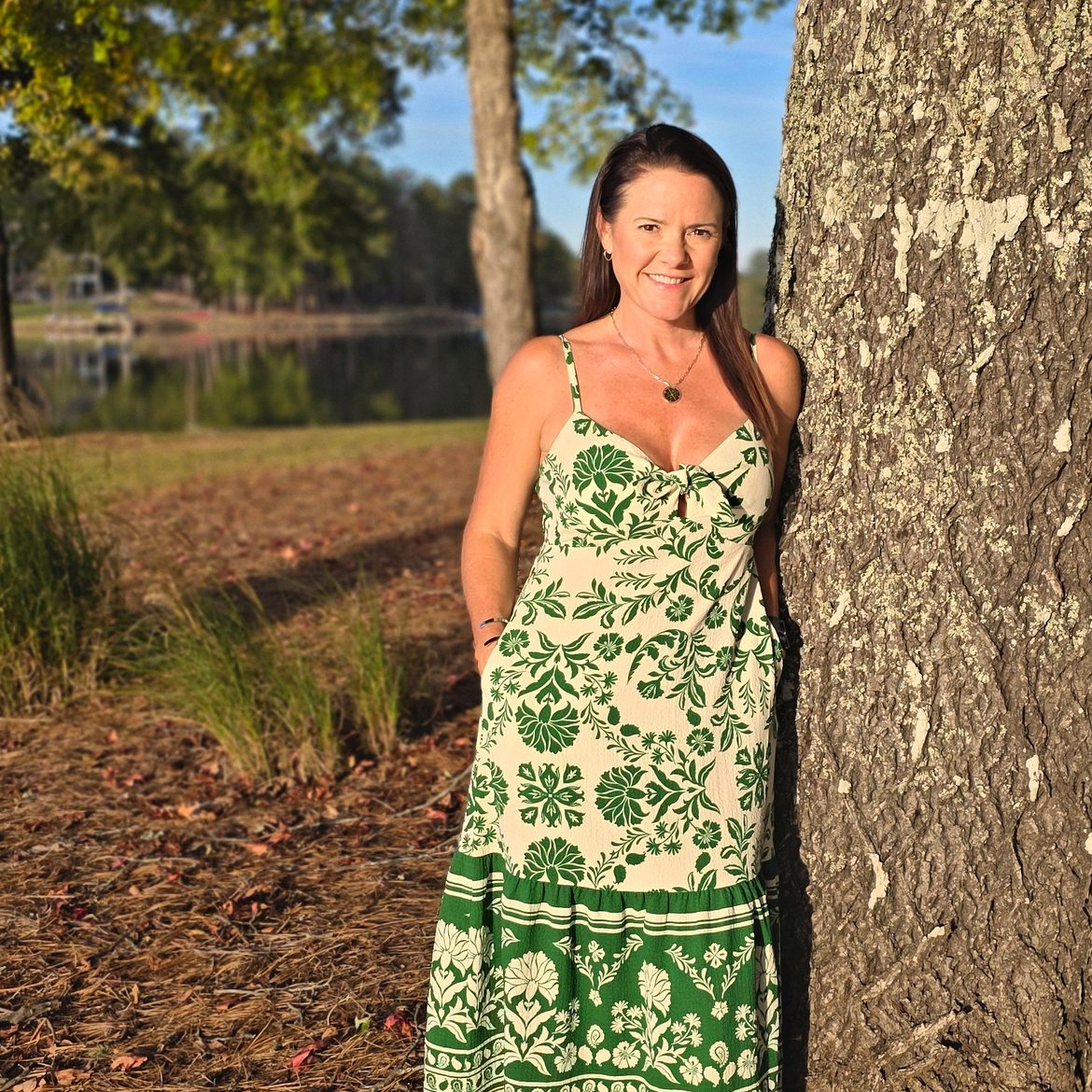 Margie Sorrell, Lake Oconee REALTOR, leaning against a tree on the Lake Oconee shoreline