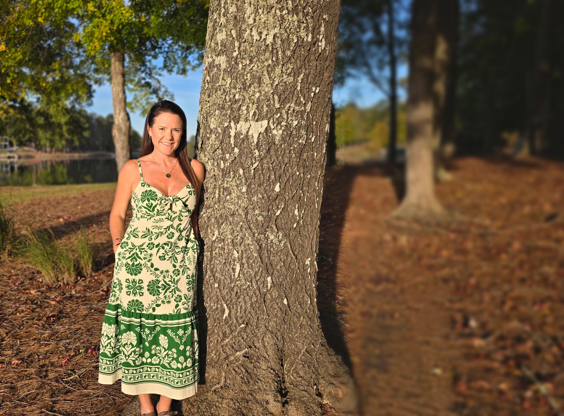 Margie Sorrell, Lake Oconee REALTOR, leaning against a tree on the Lake Oconee shoreline
