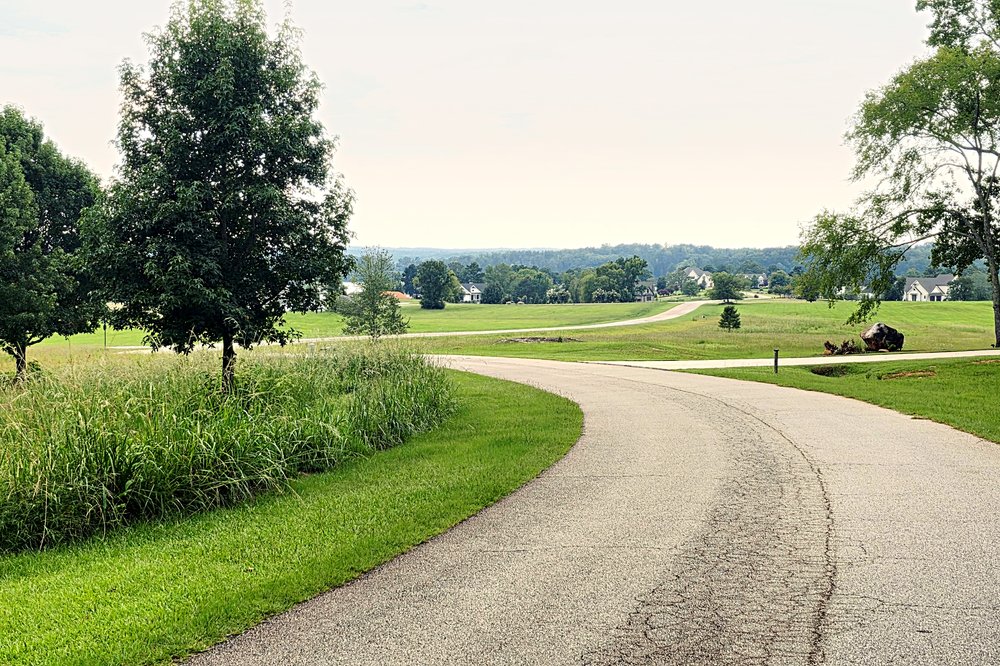 Rolling hills, open green space, and lake views inside Oconee Landing at Lake Oconee