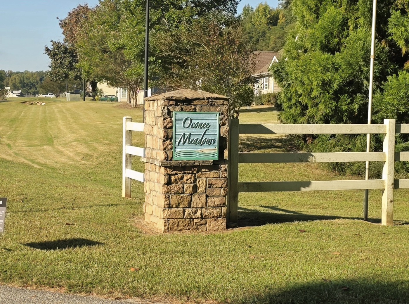 The stone entrance sign and white fence at Oconee Meadows on Alexander Road in Eatonton, Putnam County, Georgia, near Lake Oconee