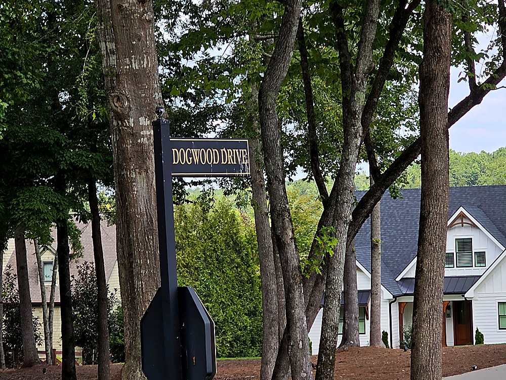 Dogwood Drive street sign in The Woods of Lake Oconee, with newly built custom homes behind it